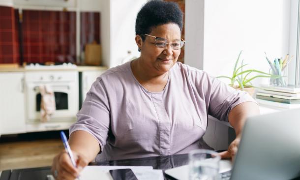 Woman writing a list of items in her home
